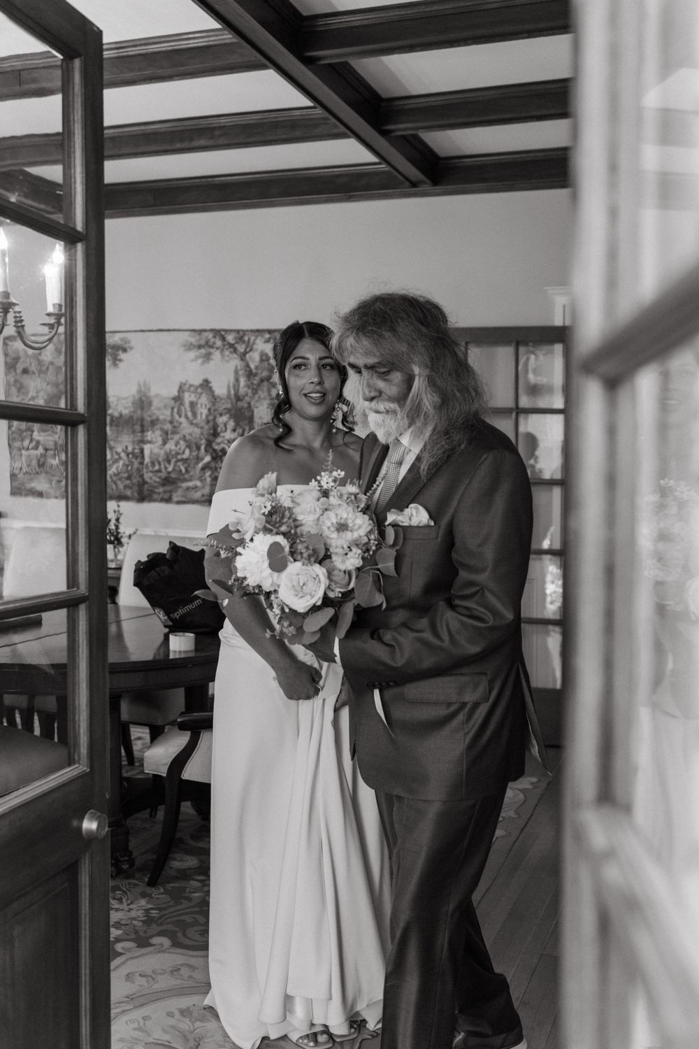 A black and white photo series showing a tender moment during a wedding ceremony in an elegant indoor venue.
