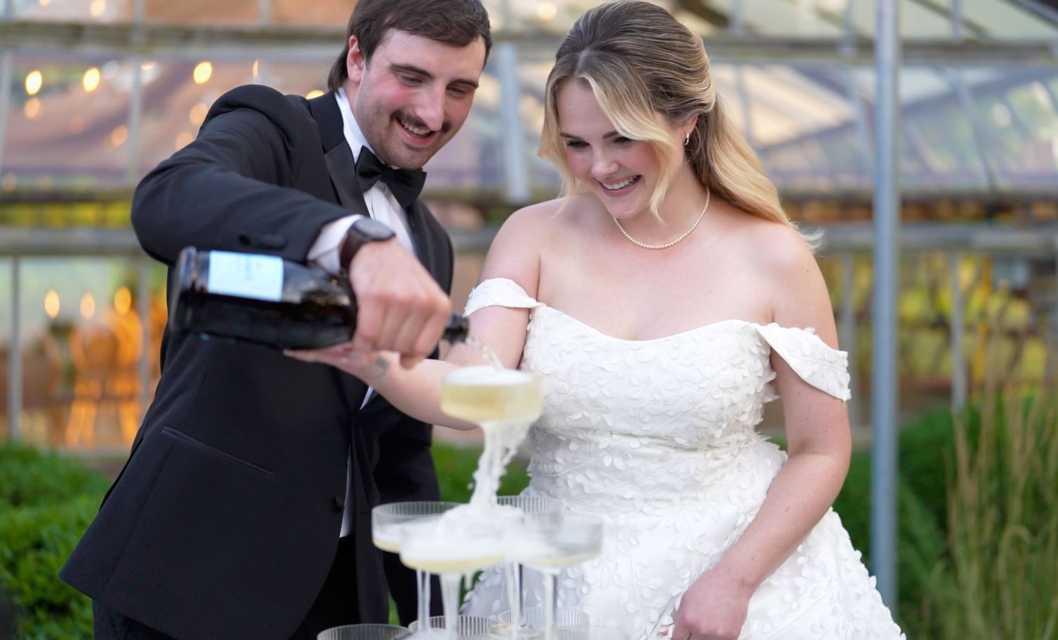 Bride and groom pouring champagne tower at elegant wedding celebration in columbus ohio
