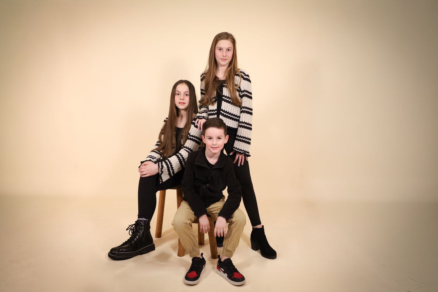 Studio portrait session with beige background showing different poses and expressions.