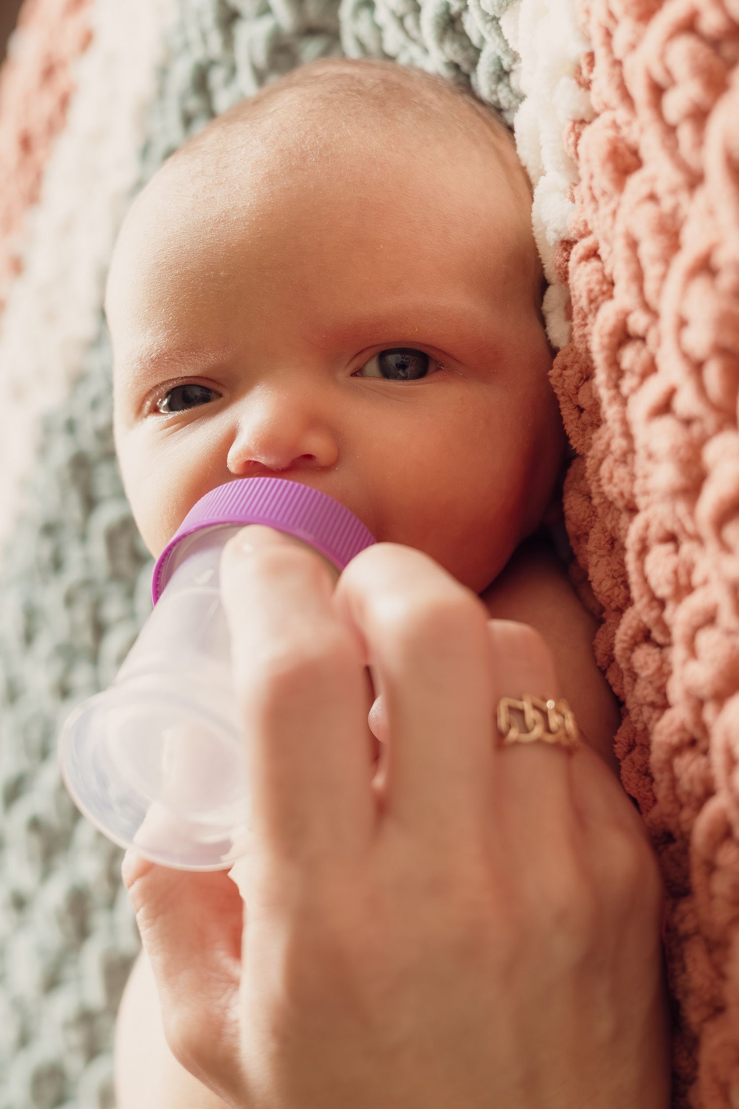A sequence of photos showing a baby with a pacifier against a textured background with a pink blanket.