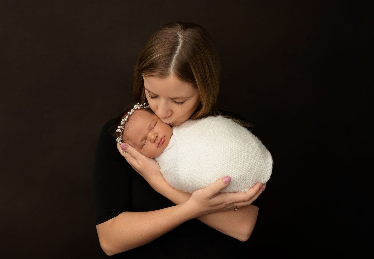 New Hampshire newborn photography of a mother holding her sleeping baby, timeless studio portrait with soft light and emotional connection.