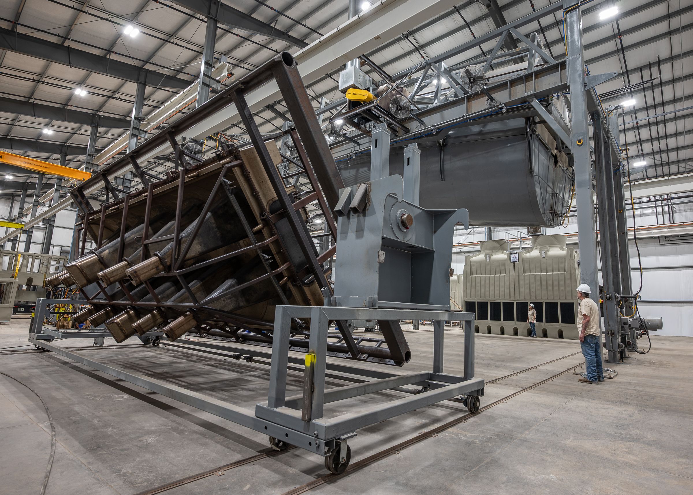 Large industrial manufacturing facility showing multiple angled metal frames and equipment in a warehouse setting.