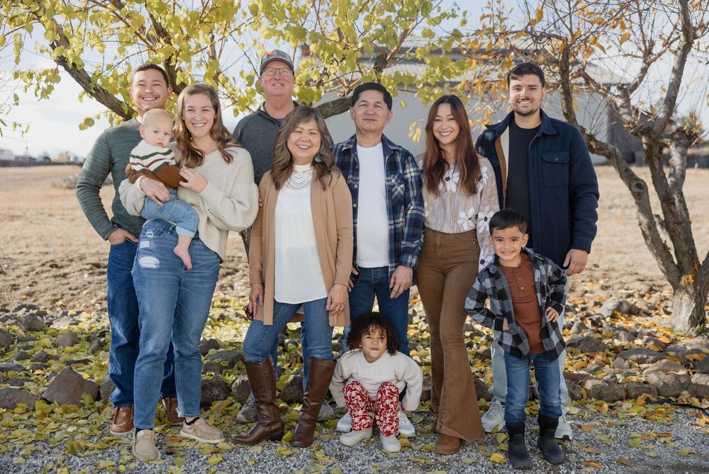 Extended family group poses together outdoors during autumn photo session.