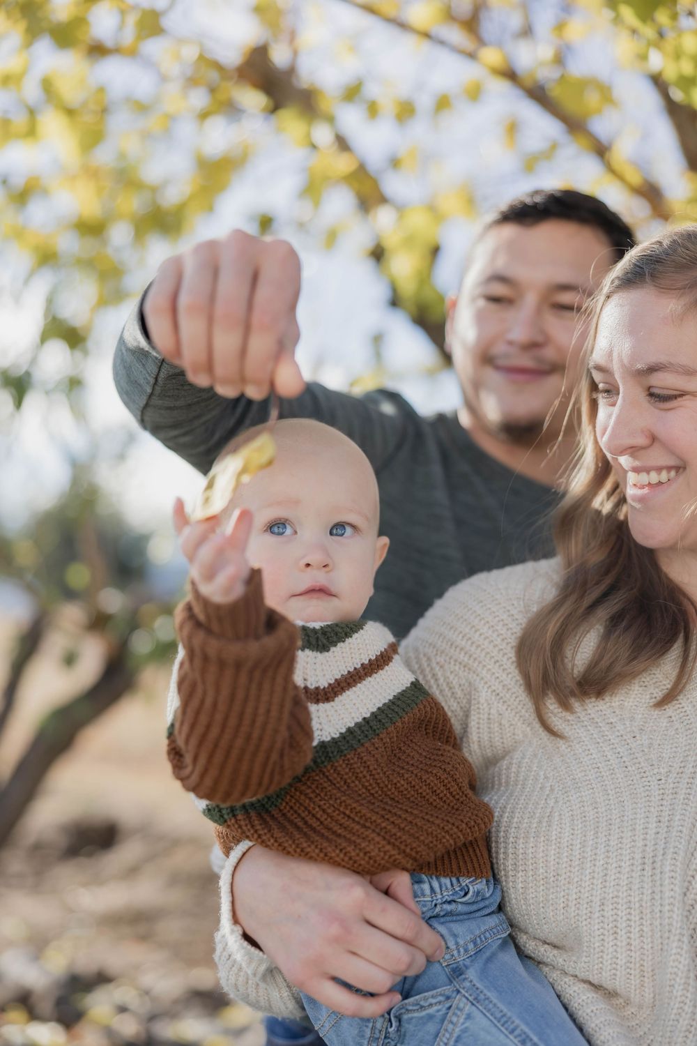 Parent and child share joyful moment together outdoors in autumn setting.