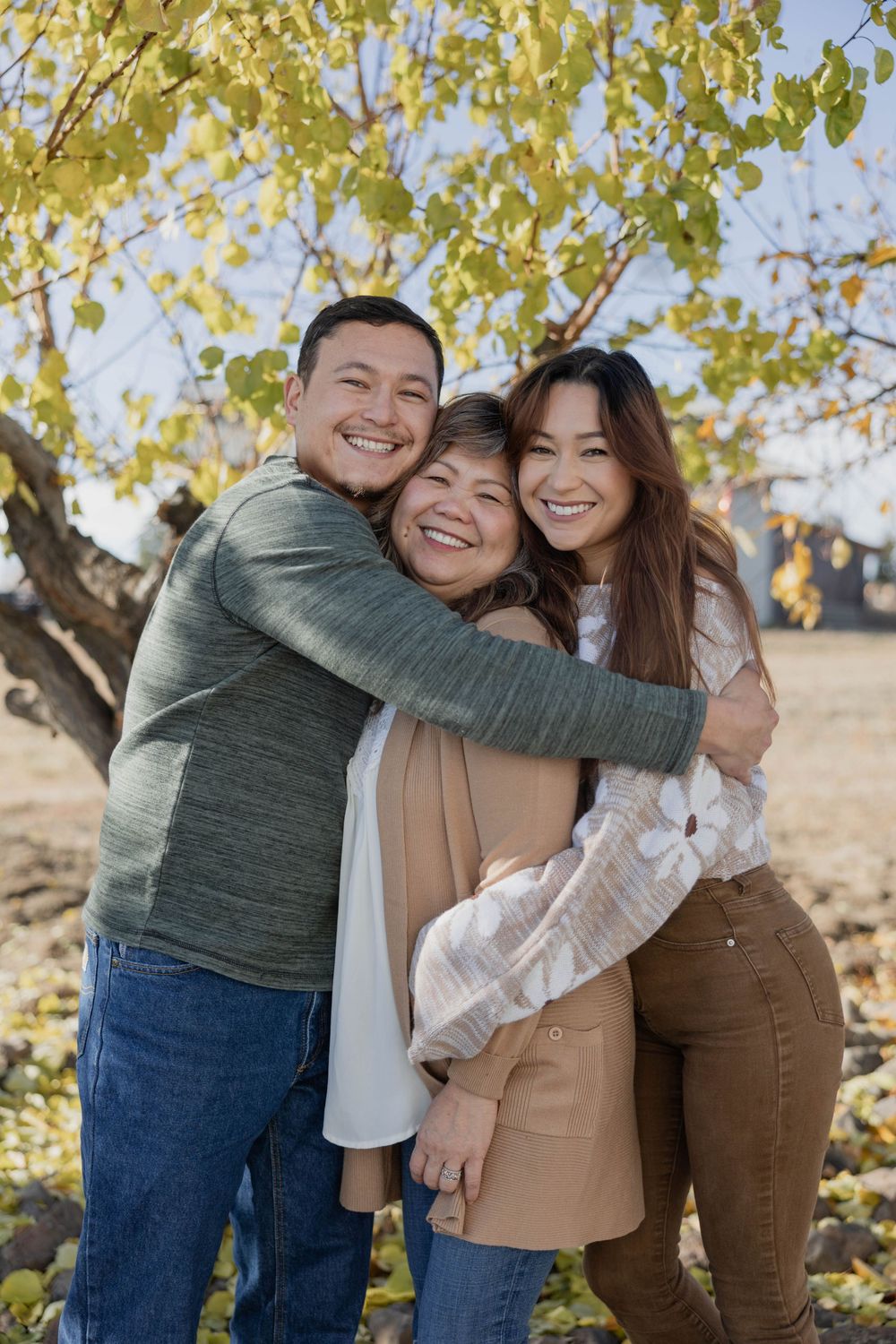 Group embracing and laughing together during outdoor autumn photo session.