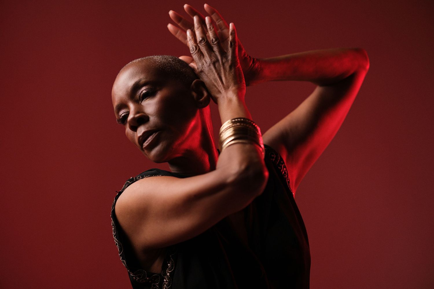 Dramatic portrait series with red lighting highlighting gold accessories and artistic poses.