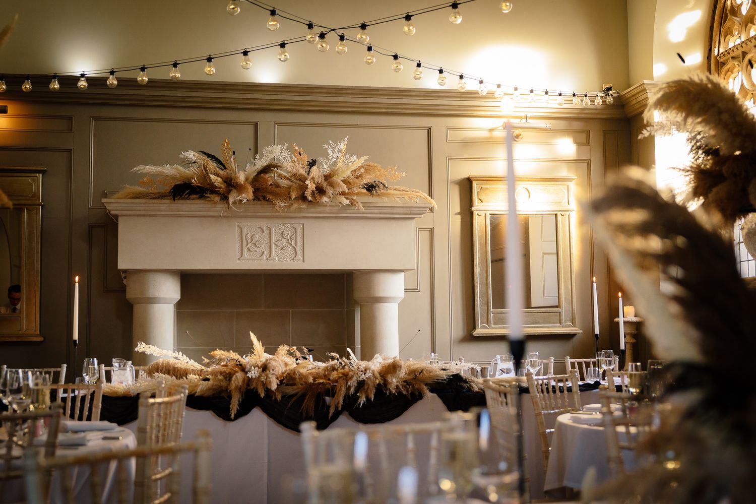 Atmospheric banquet hall with twinkling string lights and elegant table settings. Ellingham Hall