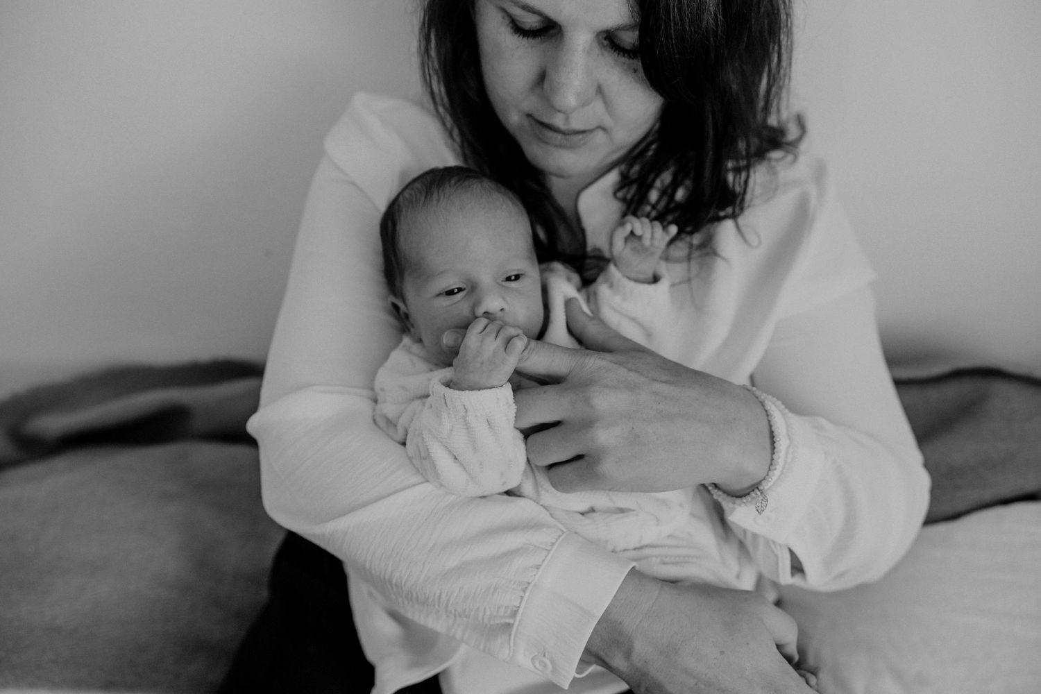 Intimate black and white portrait of newborn with caregiver.
