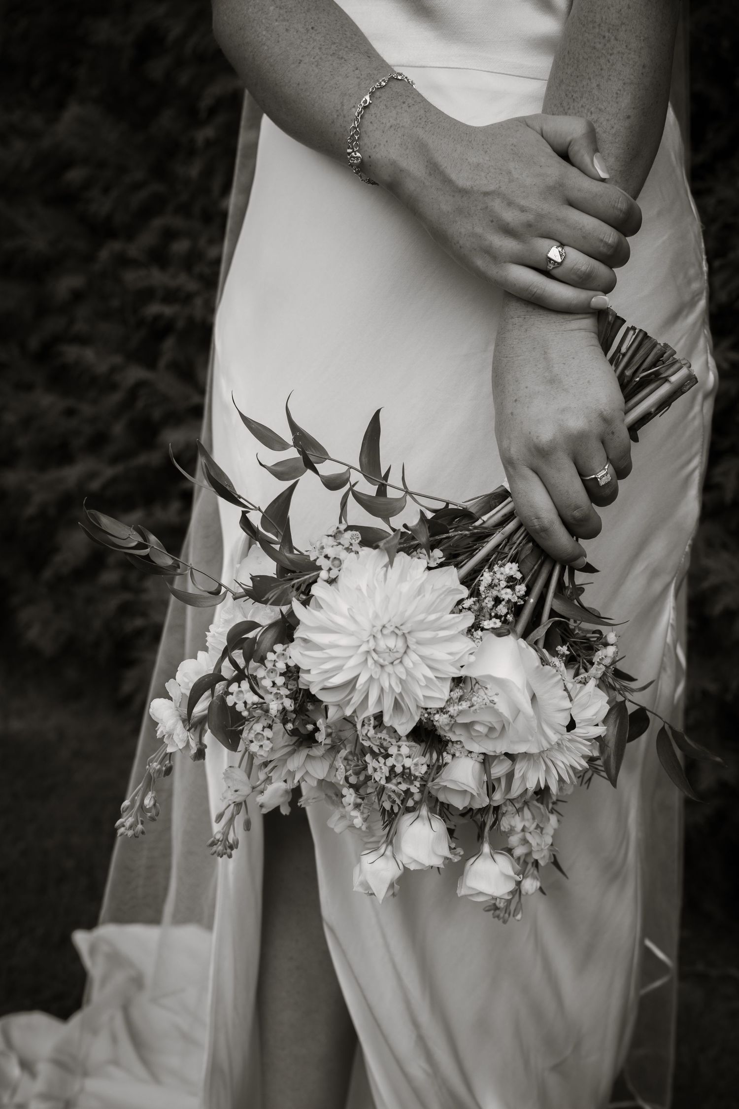 A couple walks hand in hand across a lush green lawn with a backdrop of dramatic weeping willow trees. Quinte West