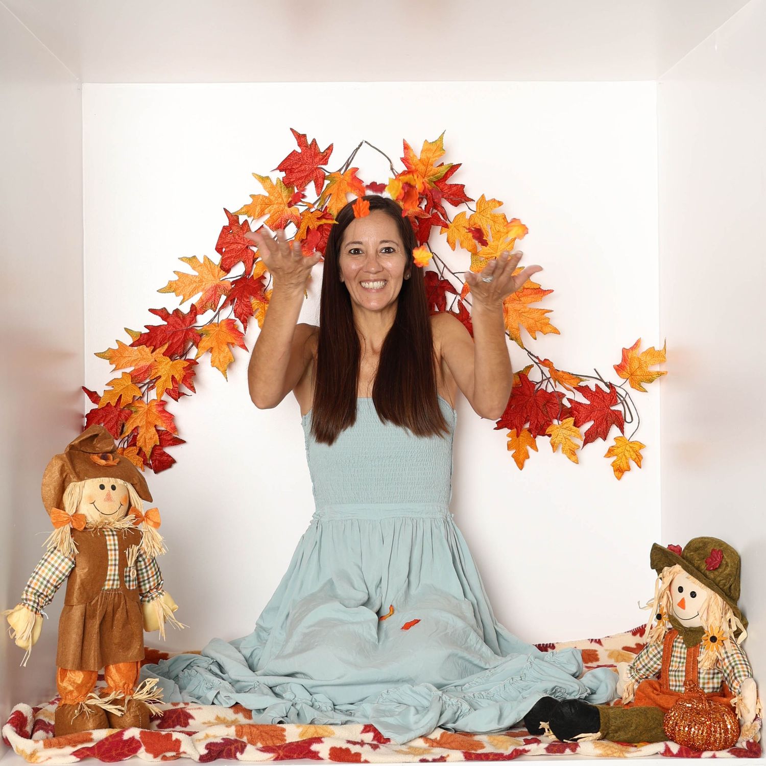 Fall photography session featuring autumn leaves, scarecrow decorations, and mint green dress. Box photography session