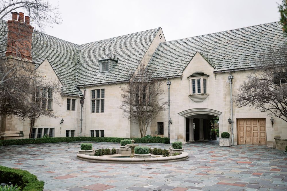 Exterior view of a stone Tudor-style building with multiple gables and ornate architectural details.