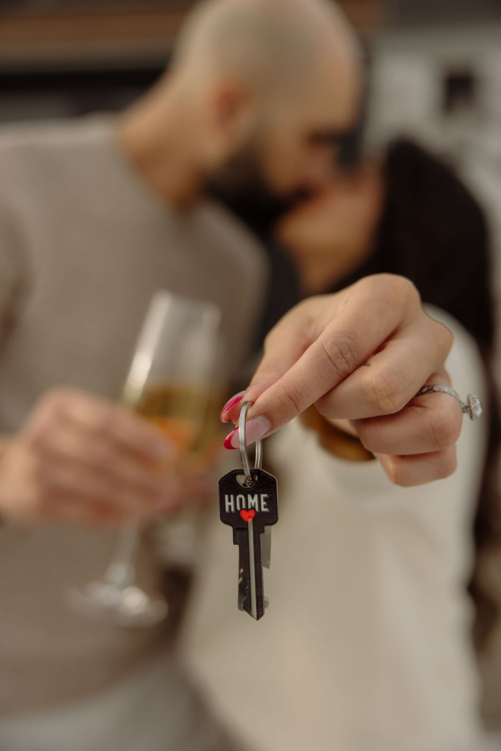 Close-up of hands holding house keys with blurred background.