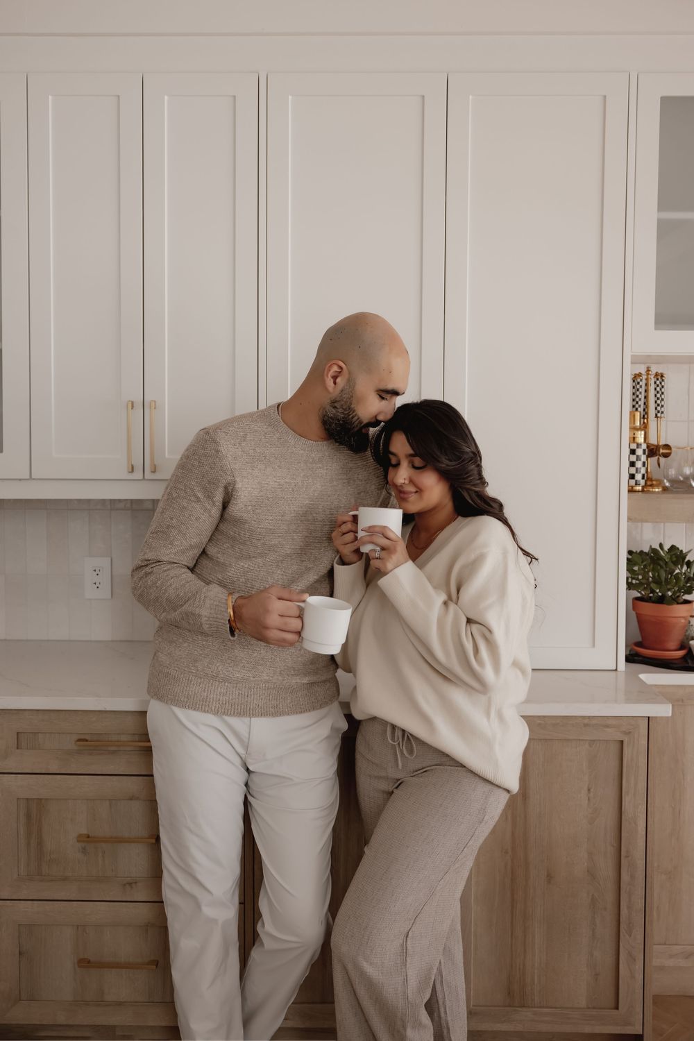 Couple in neutral colored loungewear sharing an intimate moment in thier new home in red deer alberta.