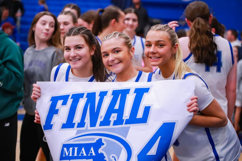 Students holding championship banner at sports event.