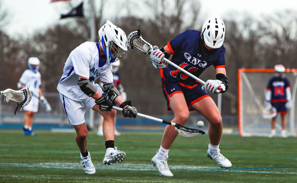 Lacrosse players battling for possession during intense game action.