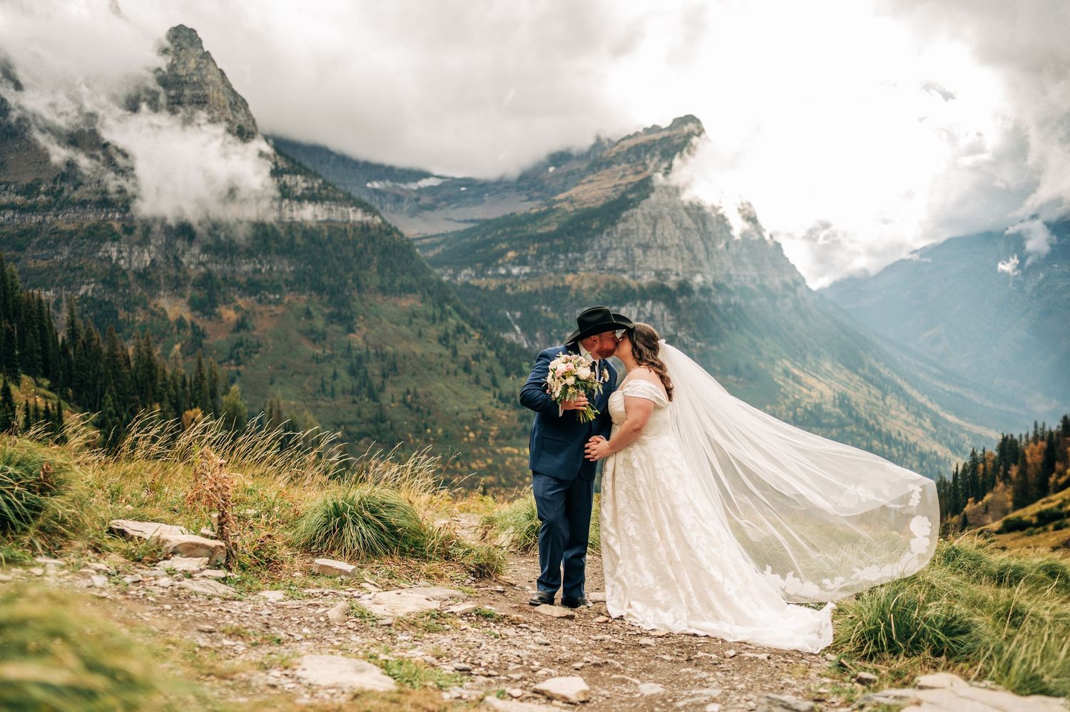A couple shares an intimate moment against a backdrop of majestic mountain peaks in the Swiss Alps.
