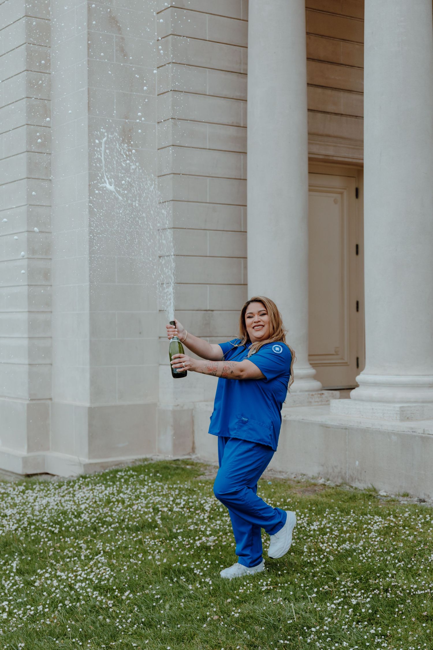 Nursing major wears her scrubs and pops champagne for her college graduation photoshoot. Taken by Bay Area Graduation Photographer.