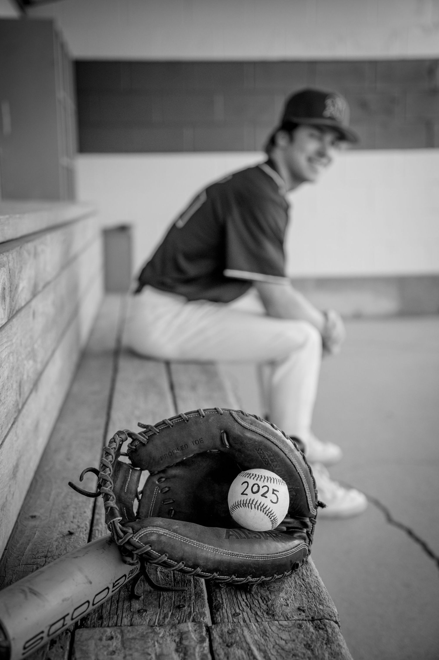 Baseball glove and ball on concrete surface with blurred background.