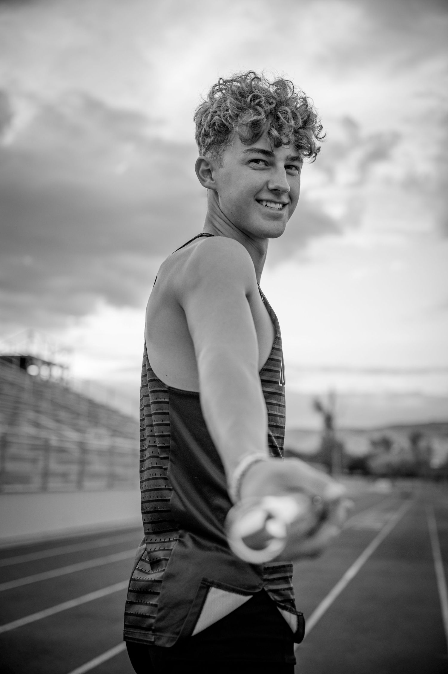 Black and white action shots on athletic track with dramatic sky.