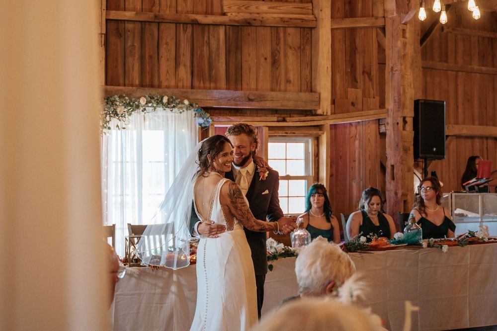 A rustic wooden barn venue decorated with string lights for a wedding reception.