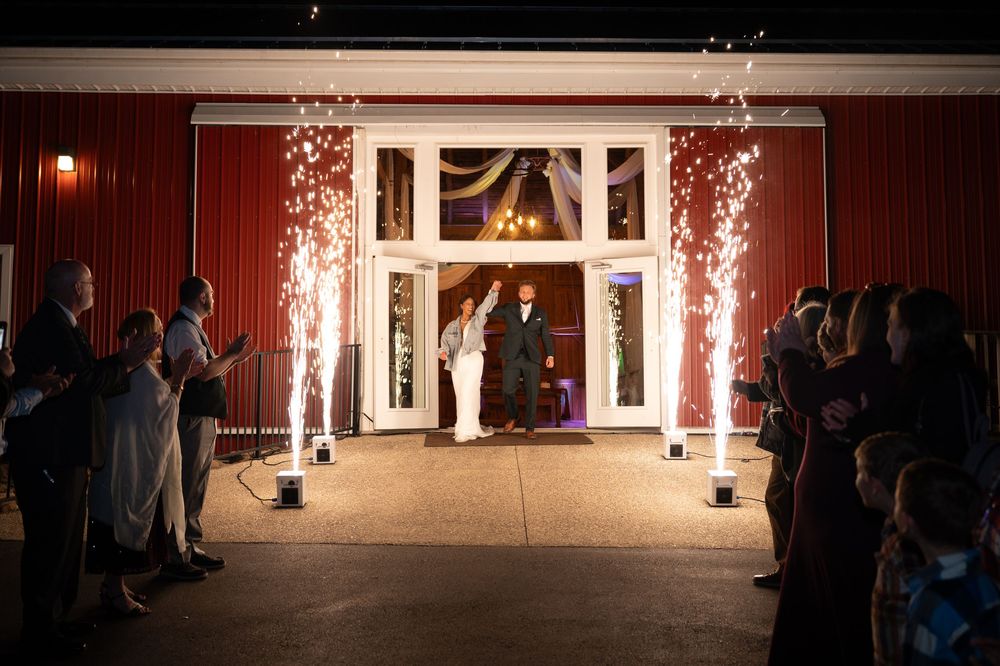 Sparklers create a magical light display during an evening outdoor wedding ceremony.