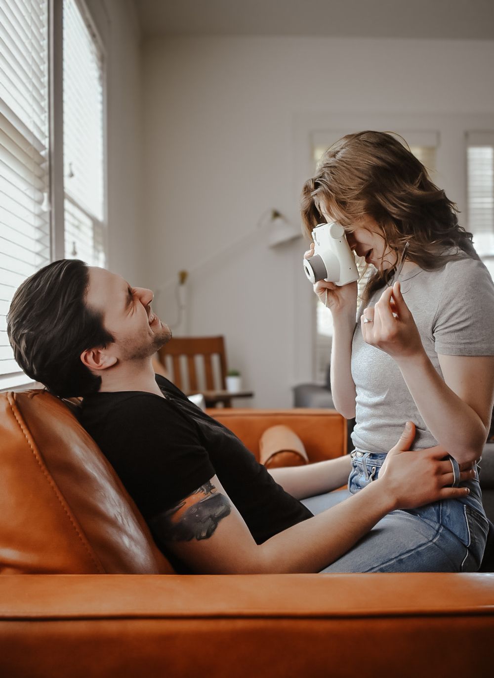 Couple sharing affectionate moments while relaxing on a leather sofa.