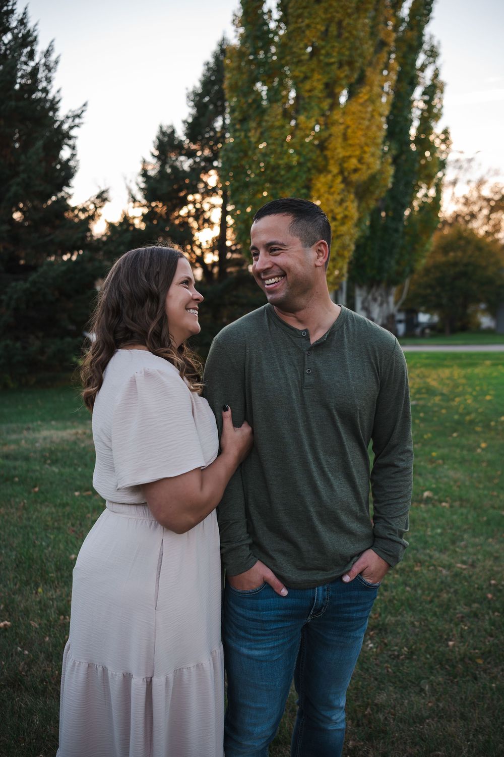 Couple sharing joyful moments together in a park during golden hour sunset.