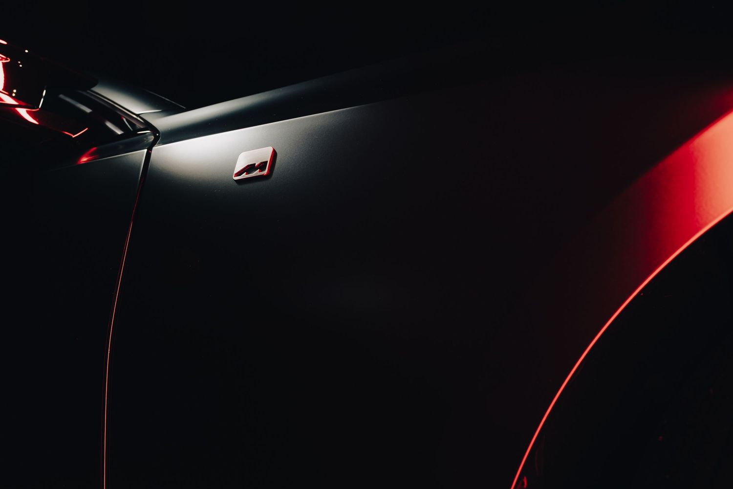 A series of close-up car detail shots showing sleek red curves and reflective surfaces in dramatic lighting.