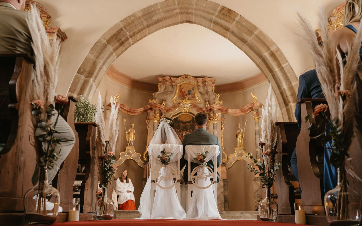 A panoramic view of a luxurious wedding ceremony venue with elegant white decor and ornate architectural details.