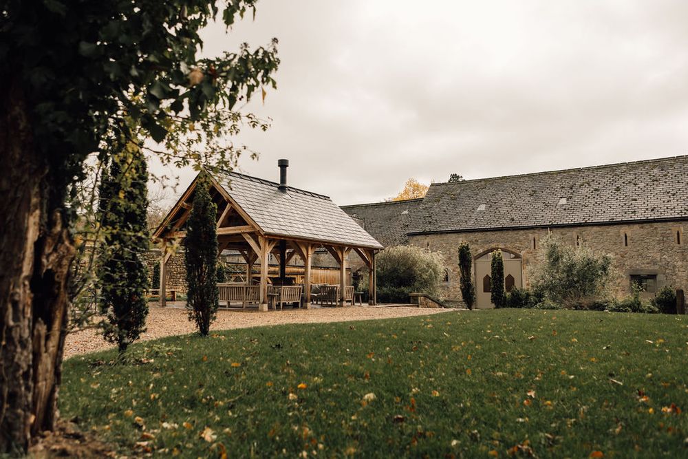 Panoramic view of a countryside wedding venue with rolling hills and historic buildings.