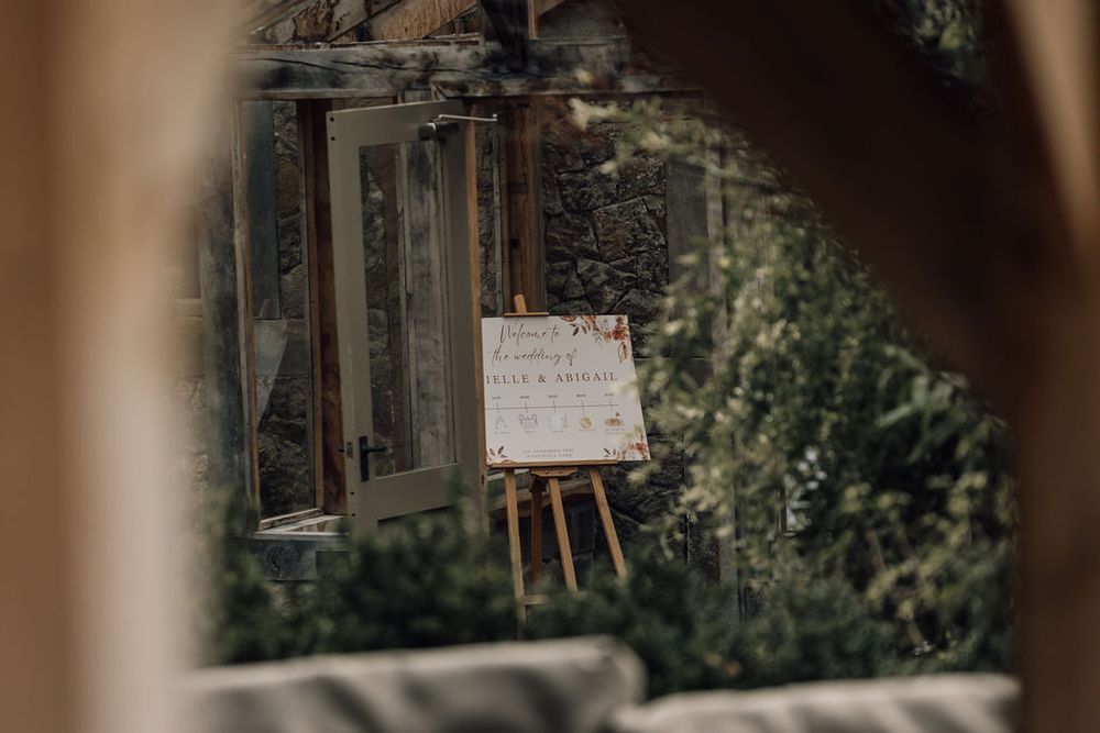 Rustic outdoor venue with natural greenery and wooden architectural details.