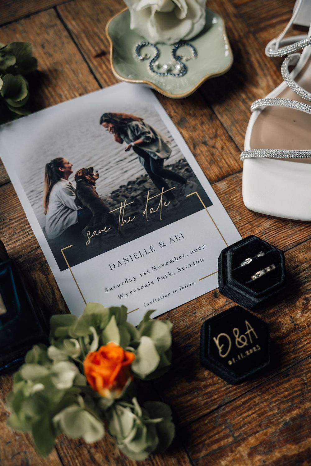 Wedding invitation with save the date photo alongside decorative elements and white shoes.