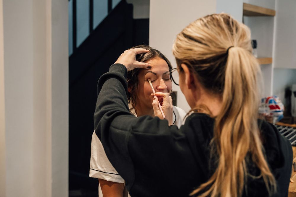Professional makeup application session in progress during wedding preparations.