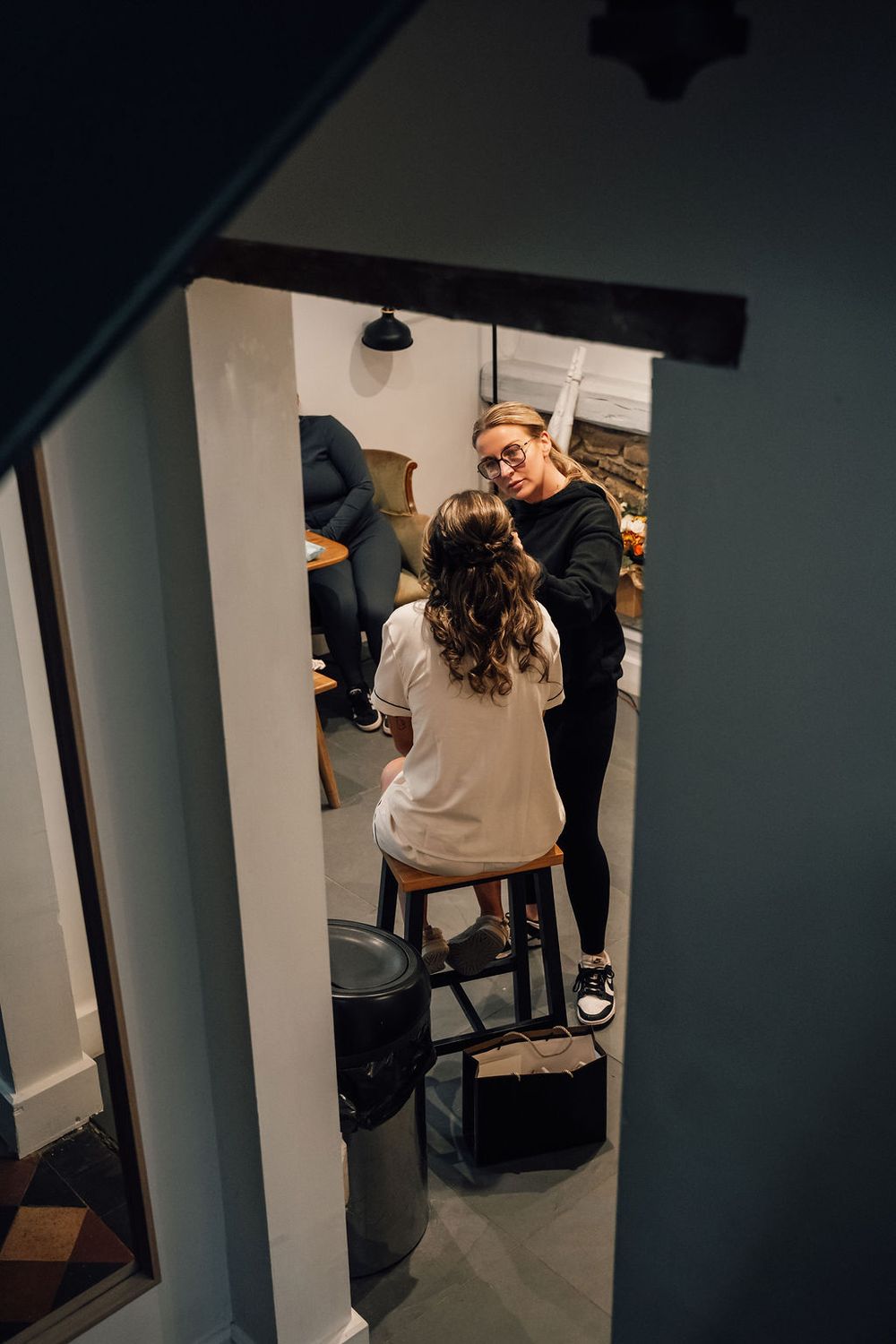 Behind-the-scenes view of wedding preparation through doorway.