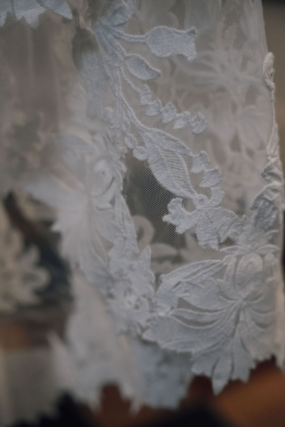 Delicate white lace details with intricate floral patterns shown in close-up view.