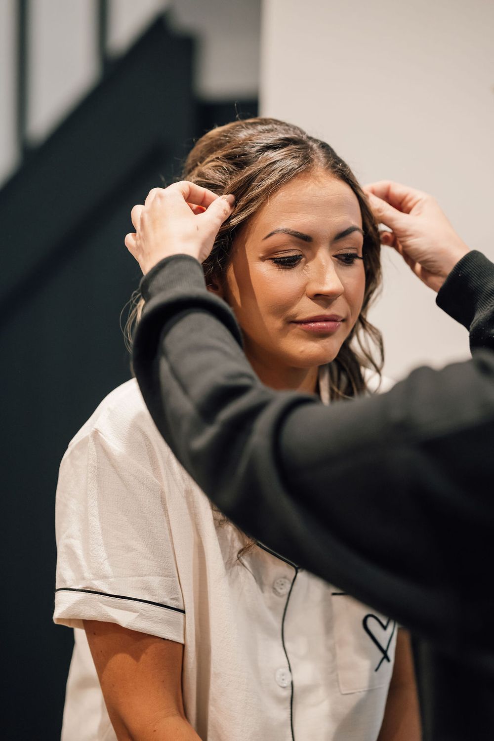 A person in white sleepwear getting ready in a modern indoor setting.