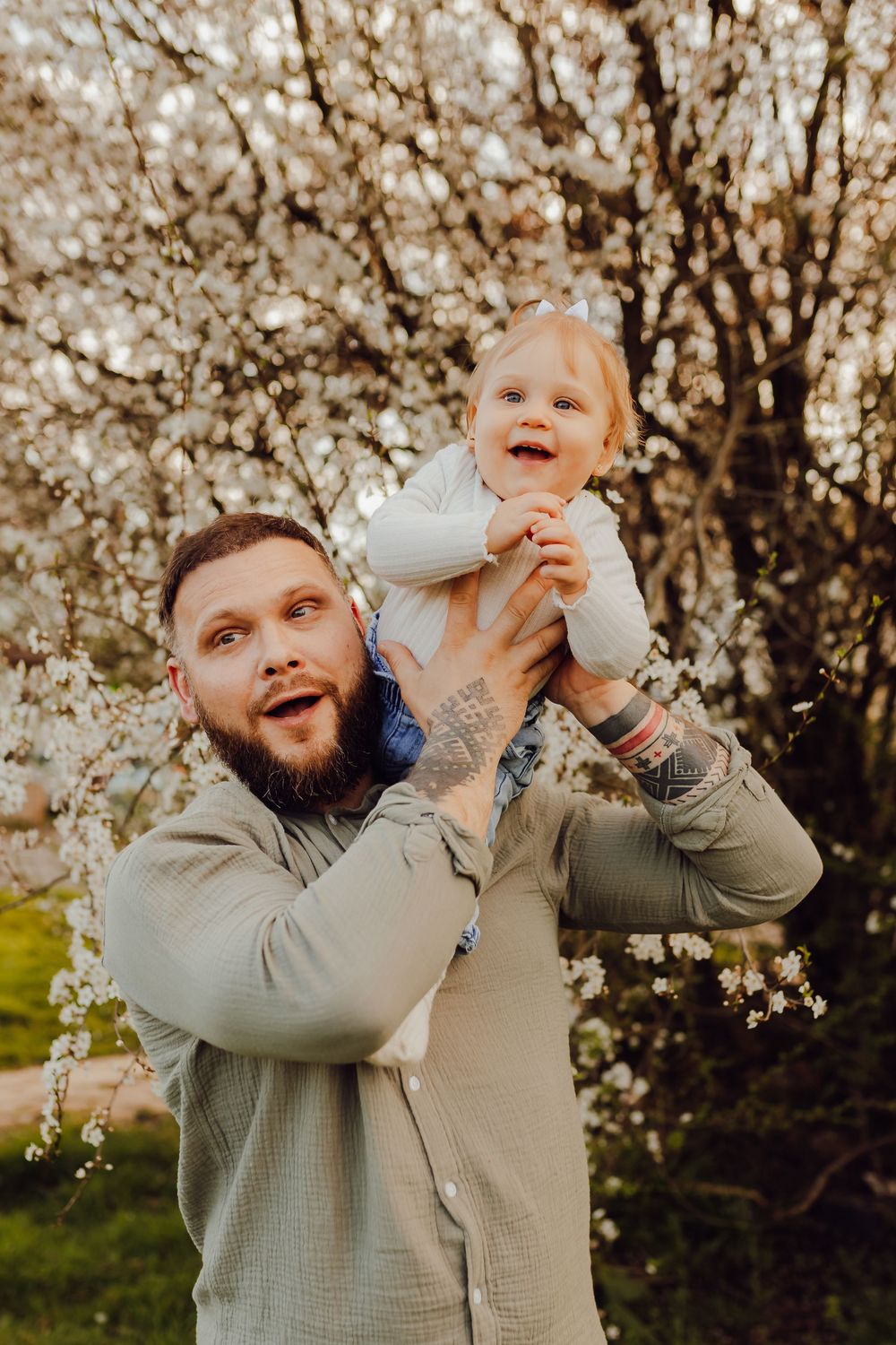 Parents and child surrounded by spring blossoms during a family photoshoot