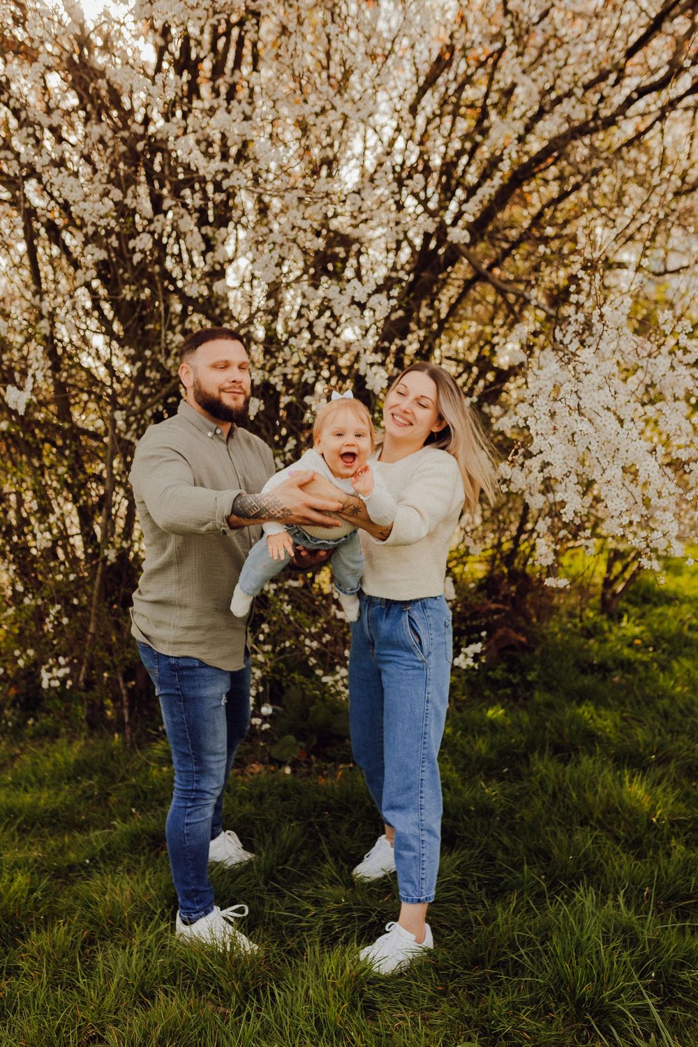 Family portrait with white spring blossoms in the background
