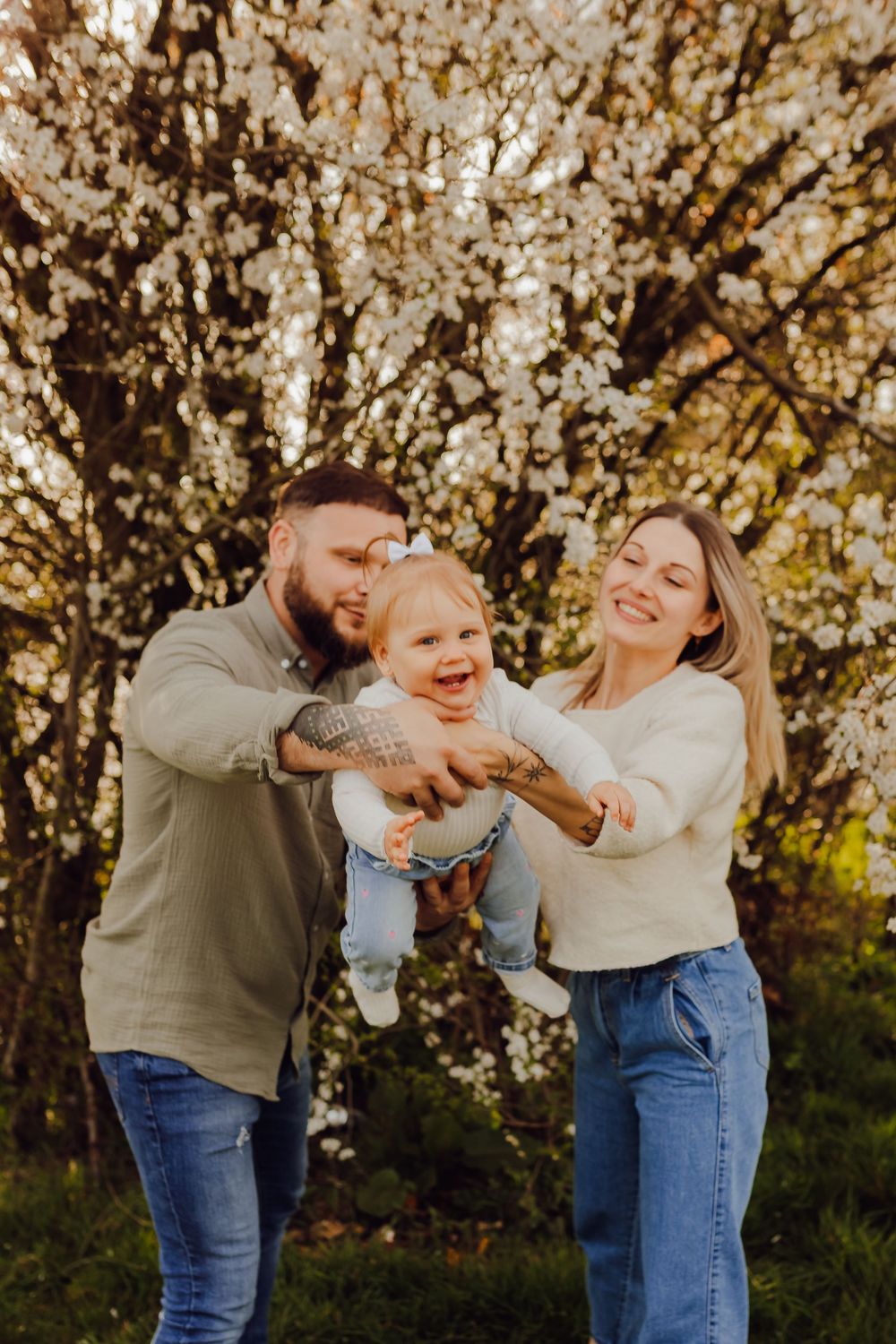 Parents and child surrounded by spring blossoms during a family photoshoot