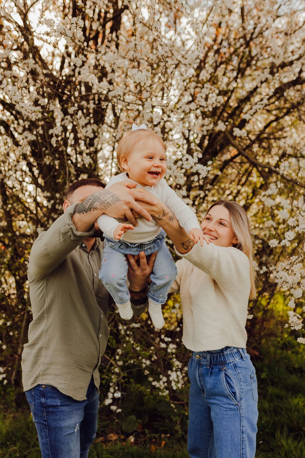 Spring family photoshoot with a flowering tree and soft natural light
