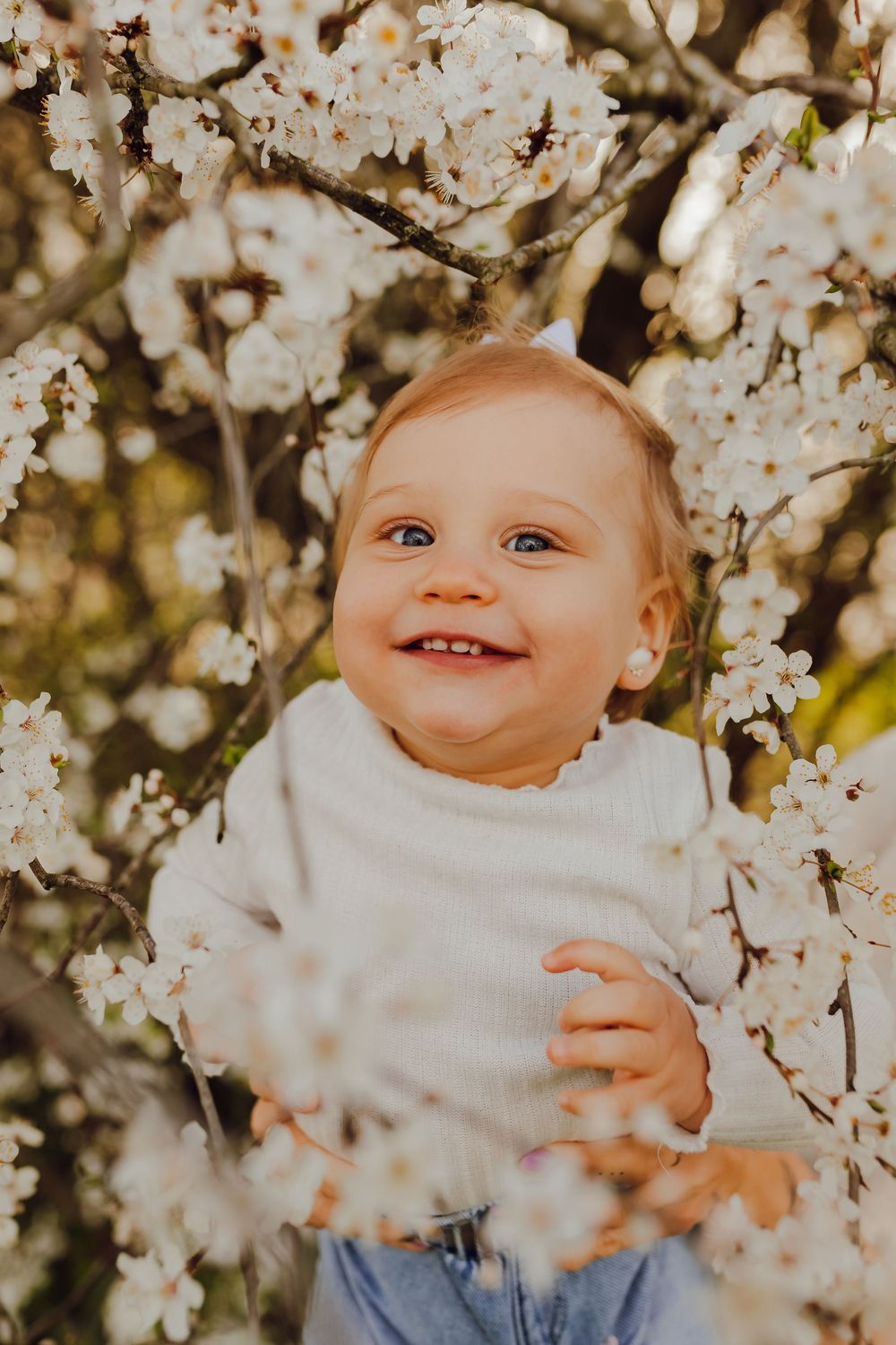 Natural family moment under a flowering tree during a spring photoshoot