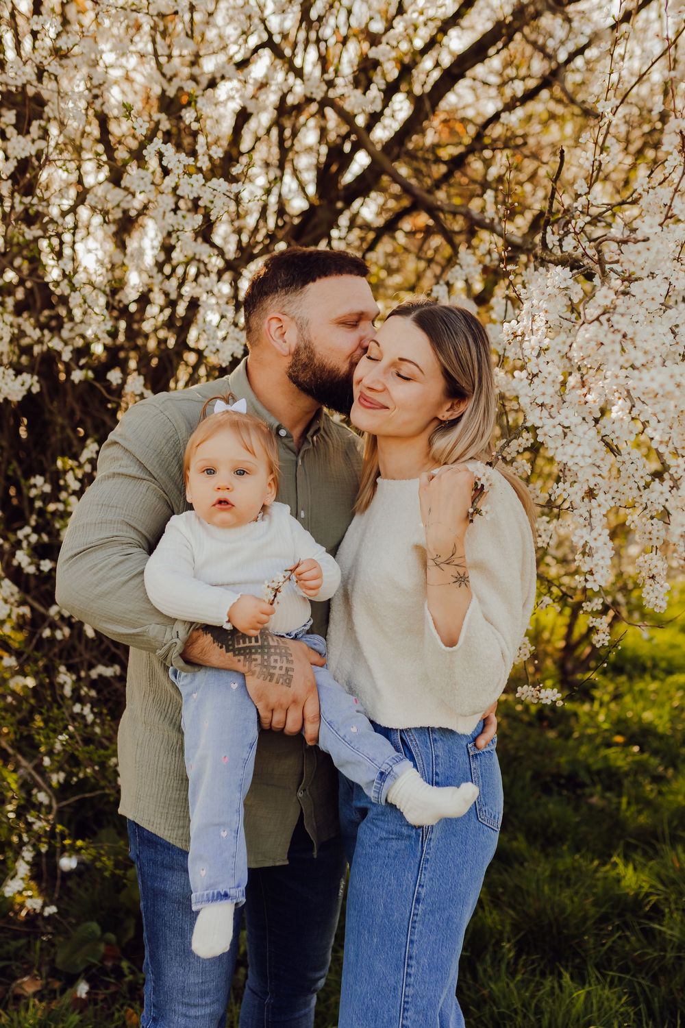 Family standing under a blooming spring tree, natural outdoor family photography
