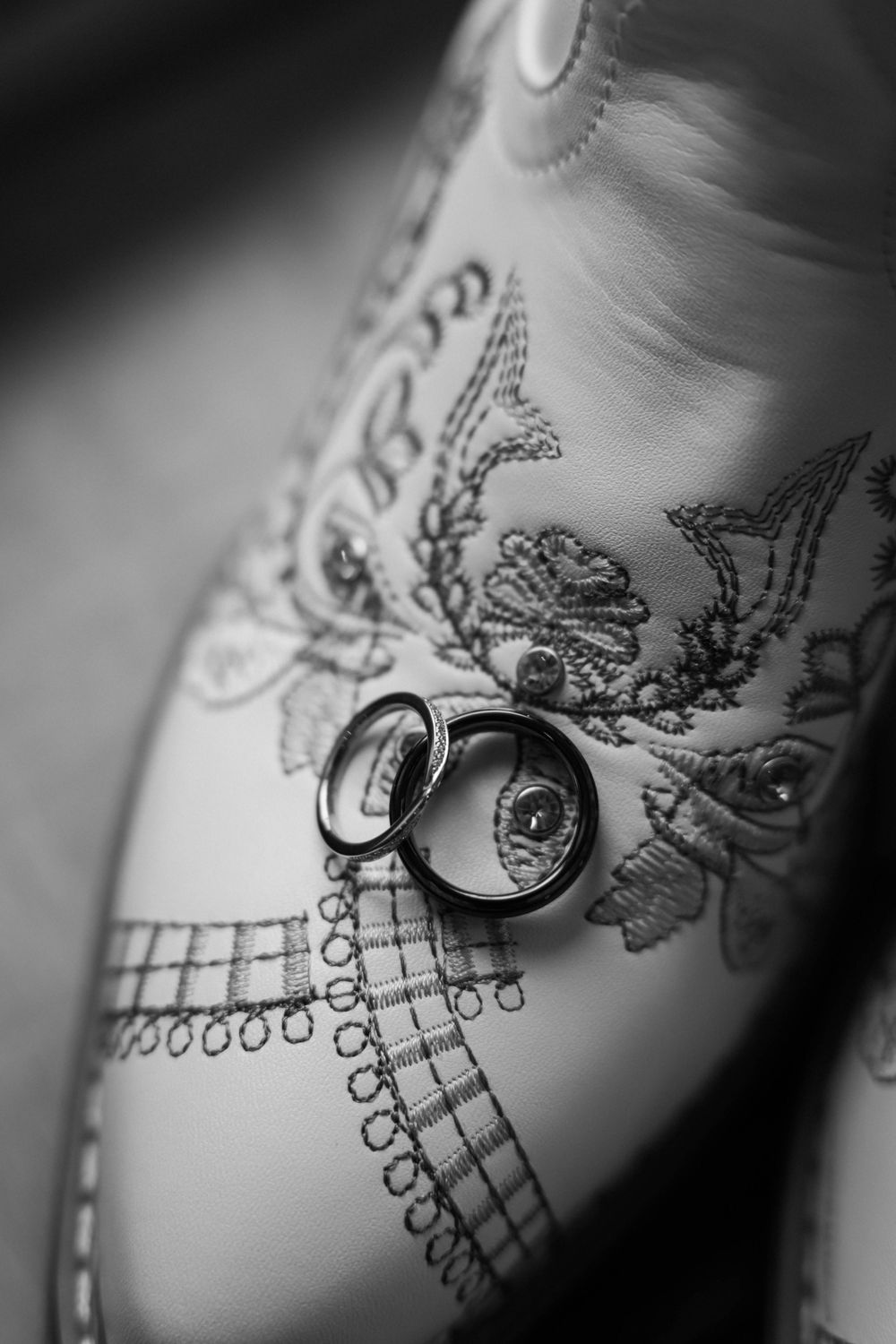Black and white close-up photos of delicate lace patterns and jewelry details on a white surface.