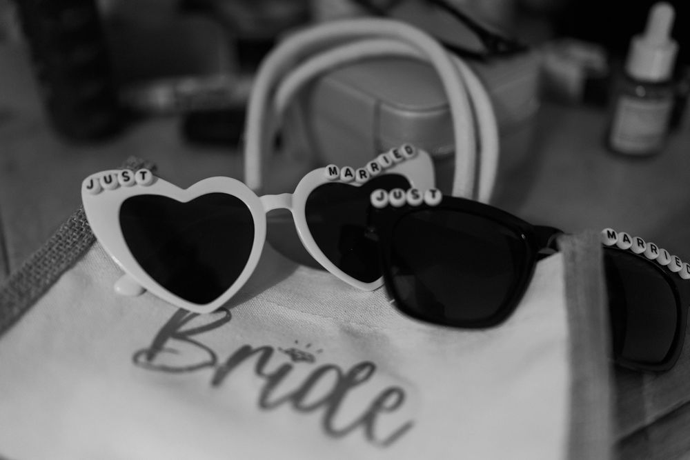 A collection of sunglasses with sparkly text decorations arranged in a black and white photo collage.