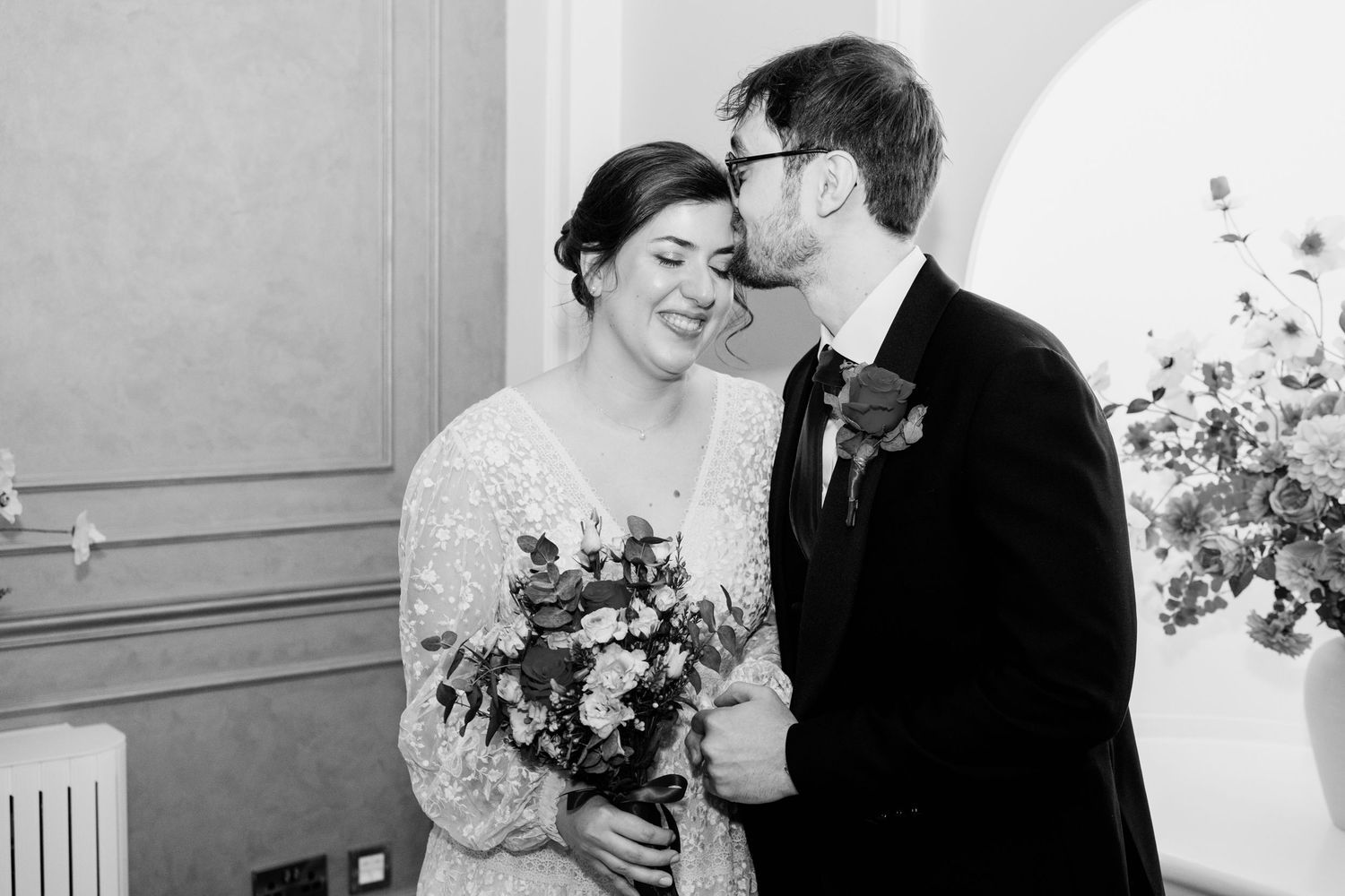 A black and white wedding photo collage showing intimate moments between a couple during their ceremony.