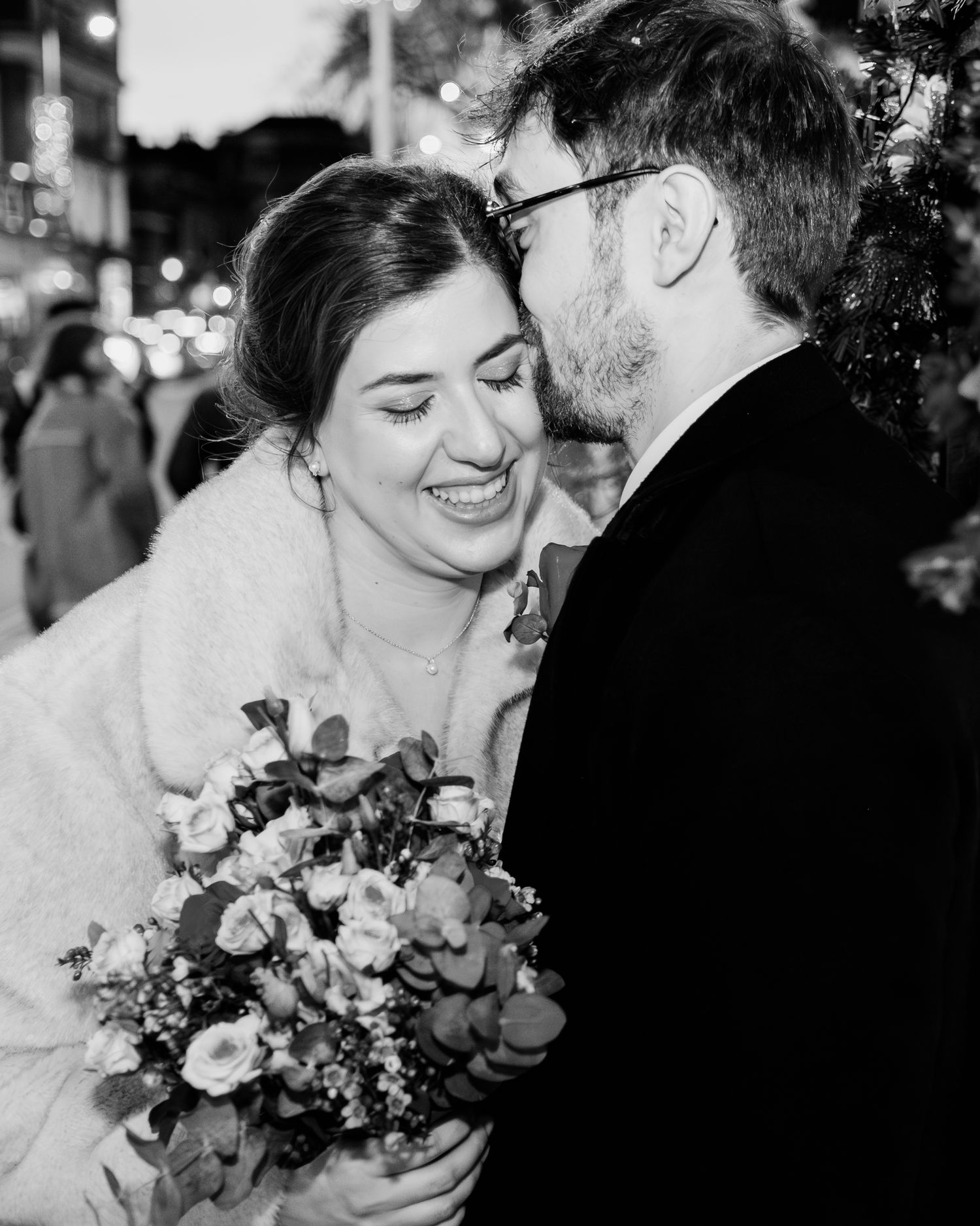 A romantic black and white photo series of a couple sharing tender moments at their wedding celebration.