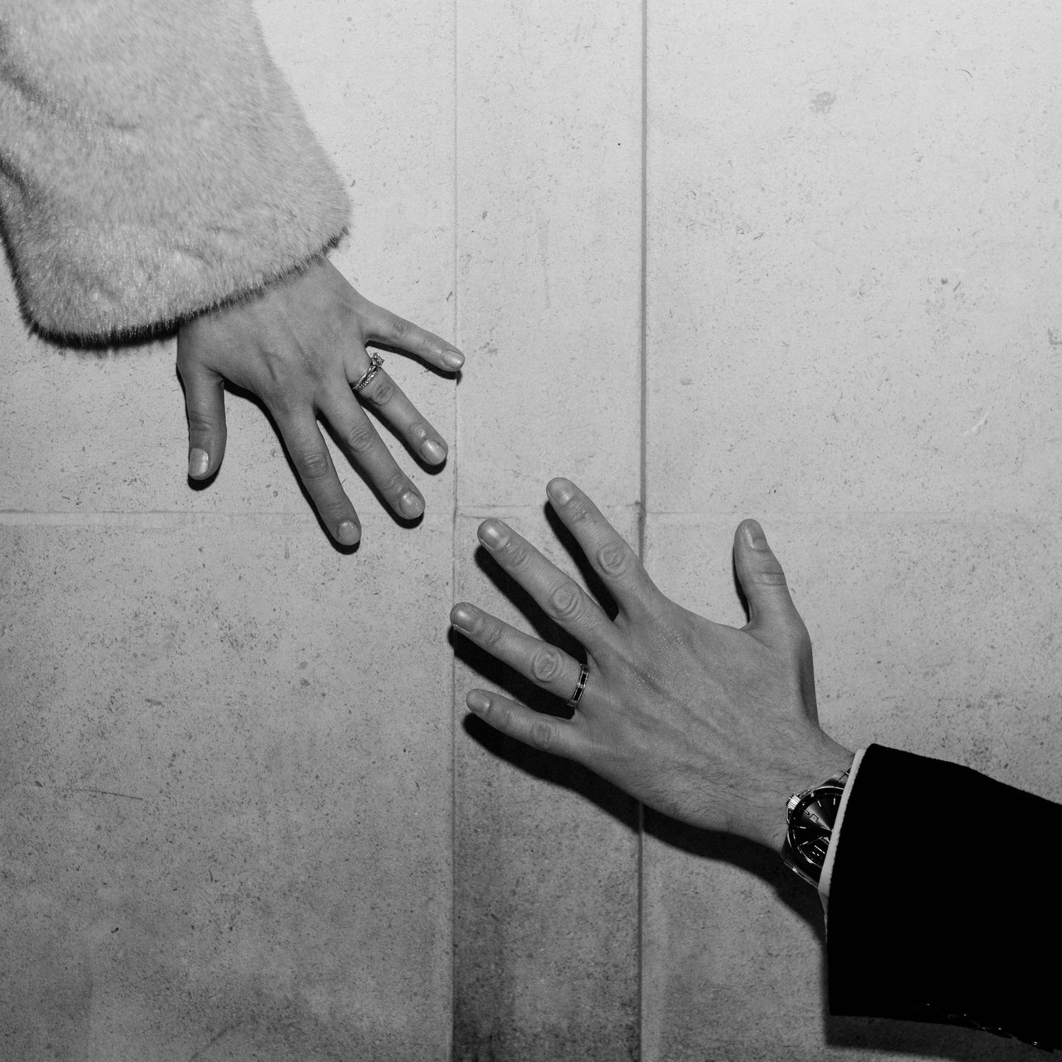 A sequence of black and white photographs showing hands in different positions against a plain wall.