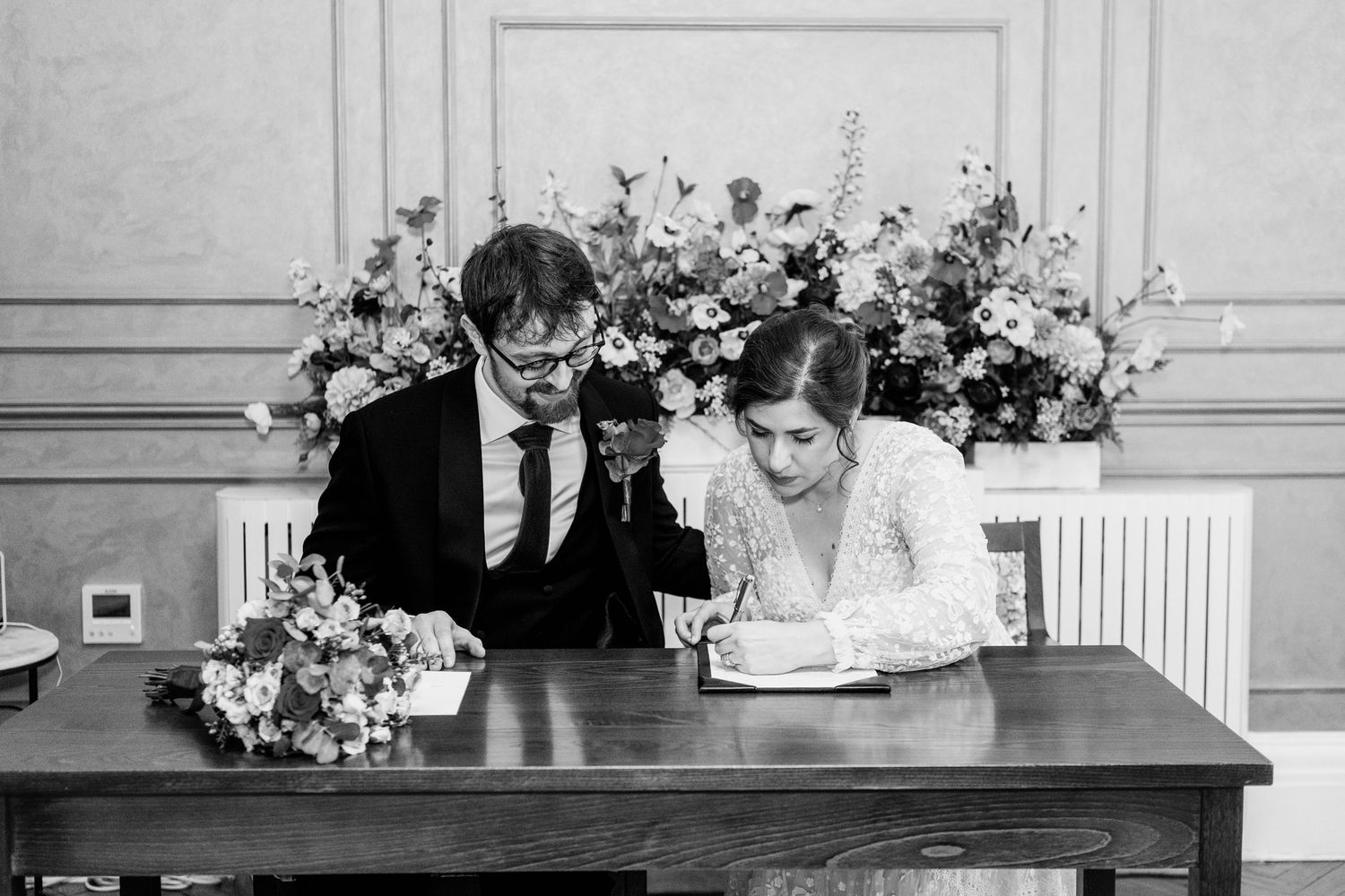 A series of black and white wedding photos arranged in a horizontal collage showing romantic moments.