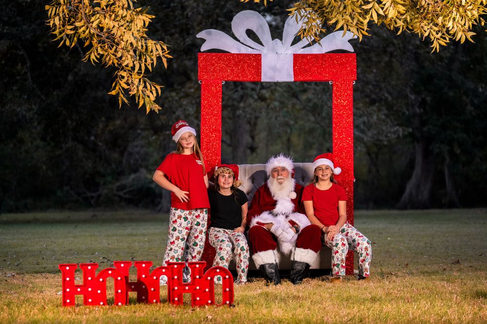 Christmas themed photo setup with red gift frame and decorative boxes outdoors.