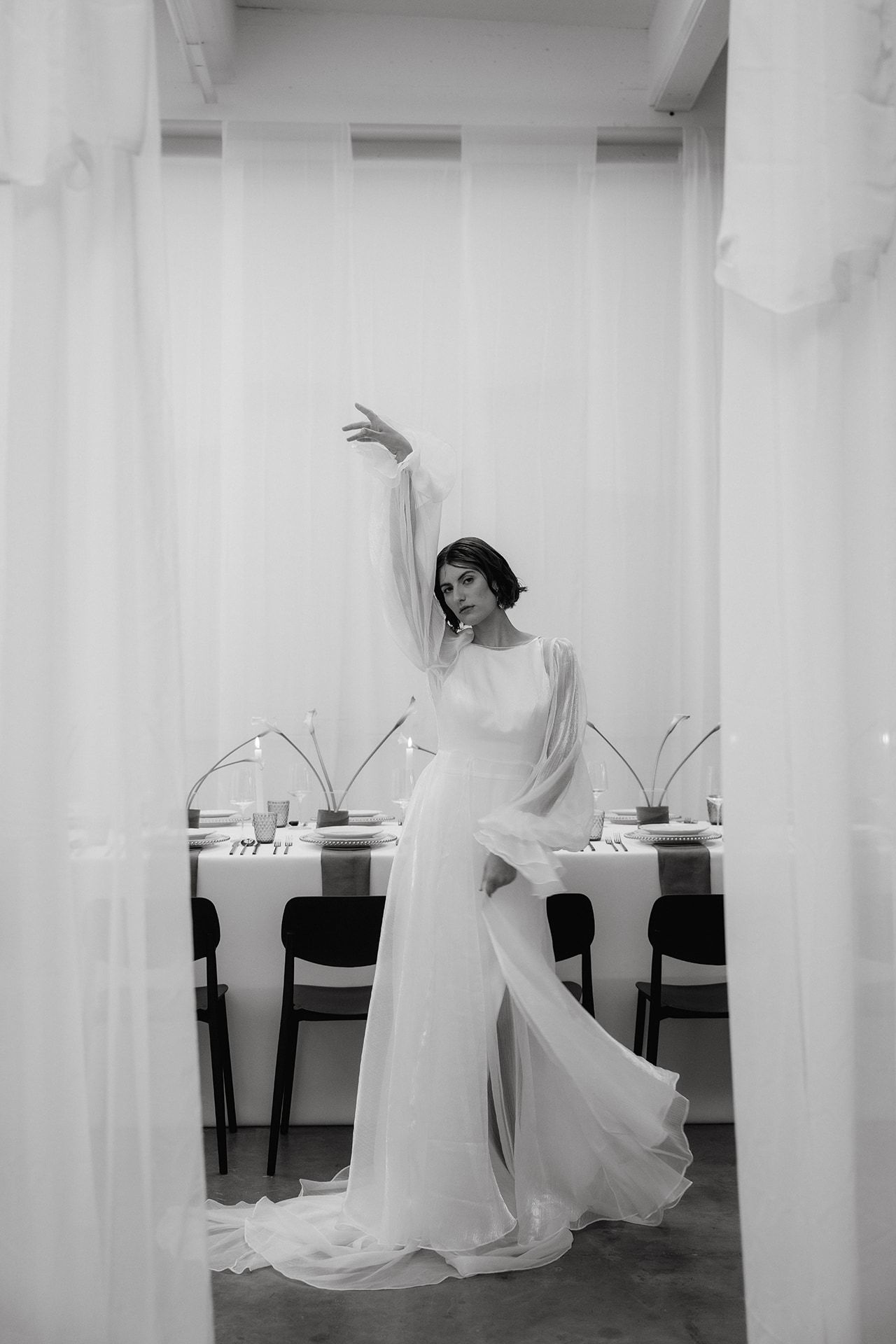 Artistic black and white photos showing graceful dance movements in a white room.